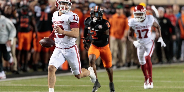 Il quarterback dell'Oklahoma Sooners Caleb Williams, n. 13, corre la palla sul campo contro gli Oklahoma State Cowboys il 27 novembre 2021 al Boone Pickens Stadium di Stillwater, Oklahoma.