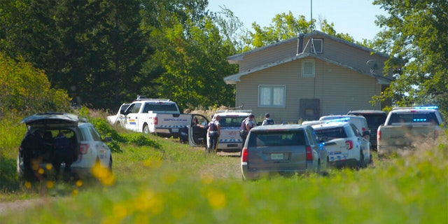 In this image taken from the video, Canadian law enforcement personnel surrounded a residence on the James Smith Cree First Nation reservation in Saskatchewan, Canada on Tuesday, September 6, 2022, as they search for a suspect in a series of stabbings.