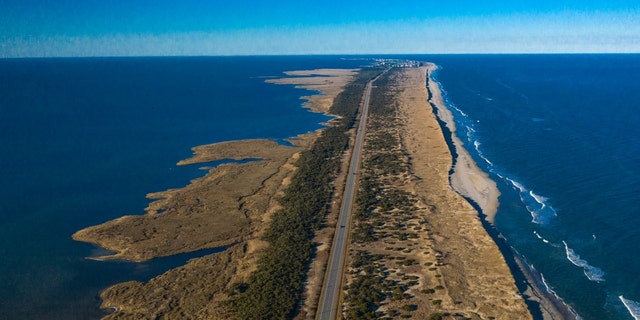 Drone aerial view of Outer Banks Highway 12 with the Atlantic Ocean and Sound on both sides, Cape Hatteras National Seashore. 