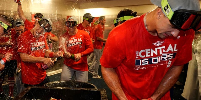 St. Louis Cardinals' Jack Flaherty, right, celebrates with teammates including Andrew Knizner, center, and Tommy Edman, left, after defeating the Milwaukee Brewers in a baseball game to win the National League Central title Tuesday, Sept. 27, 2022, in Milwaukee.