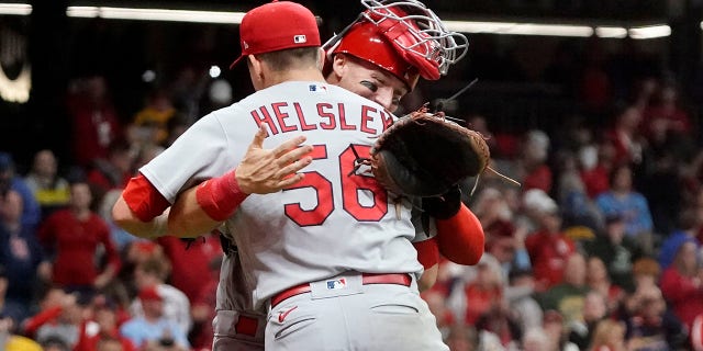 St. Louis Cardinals' Andrew Knizner and Ryan Helsley celebrate after defeating the Milwaukee Brewers in a baseball game to win the National League Central title Tuesday, Sept. 27, 2022, in Milwaukee.