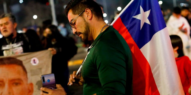 FILE: An opponent of the new Constitution listens to the partial results of a plebiscite on whether the new Constitution will replace the current Magna Carta imposed by a military dictatorship 41 years ago, in Santiago, Chile, Sunday, Sept. 4, 2022.
