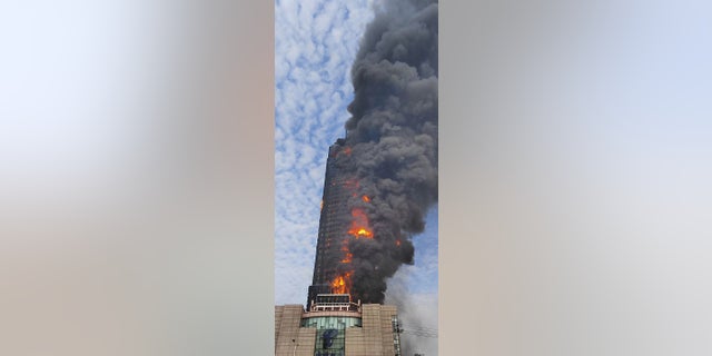 Flames and smoke rise from a 218-meter-tall office building on Sept. 16, 2022, in Changsha, Hunan Province of China.
