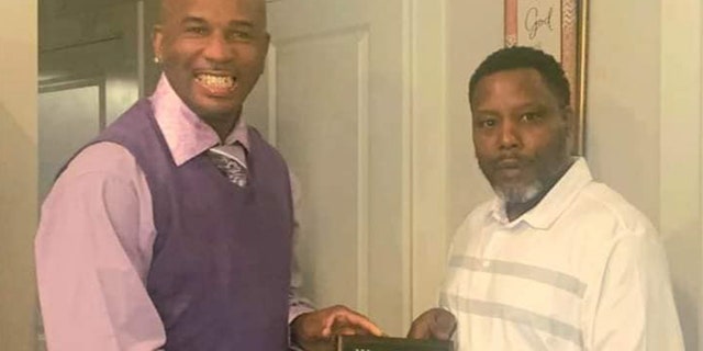 Detrick Saulter hands out a Father of the Month award to one of his childhood friends, Wade Jackson.