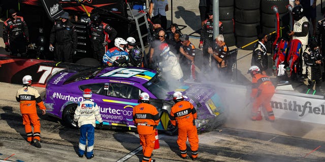 Safety crew personnel assist Cody Ware, driver of the No. 51 Nurtec ODT Ford, after spinning into the pit area during the Autotrader EchoPark Automotive 500 at Texas Motor Speedway in Fort Worth, Texas, on Sept. 25, 2022.