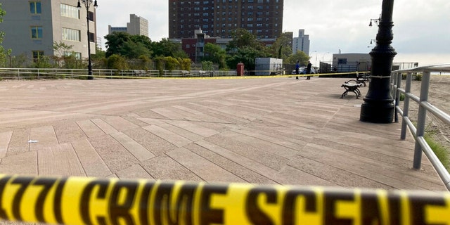 La cinta de la escena del crimen se extiende a lo largo de una sección del paseo marítimo de Coney Island cerca de un tramo de playa donde tres niños fueron encontrados muertos en las olas el lunes 12 de septiembre de 2022 en Nueva York. 