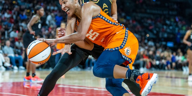 Connecticut Sun forward Alyssa Thomas (25) battles on the dribble inside with Las Vegas Aces center Kiah Stokes, top, during the second half in Game 1 of a WNBA basketball final playoff series Sunday, Sept. 11, 2022, in Las Vegas.