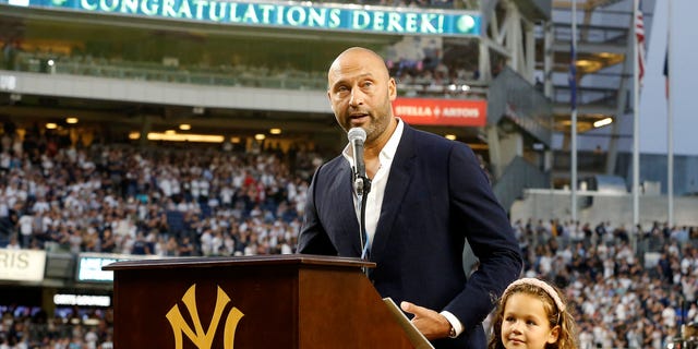 Baseball Hall of Famer Derek Jeter addresses fans with his daughter Bella as he is honored by the New York Yankees before the game against the Tampa Bay Rays at Yankee Stadium in the Bronx on Sept. 9, 2022.