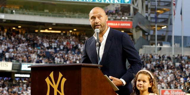 Baseball Hall of Famer Derek Jeter speaks to the fans alongside his daughter Bella as he is honored by the New York Yankees before a game against the Tampa Bay Rays at Yankee Stadium Sept. 9, 2022, in the Bronx.