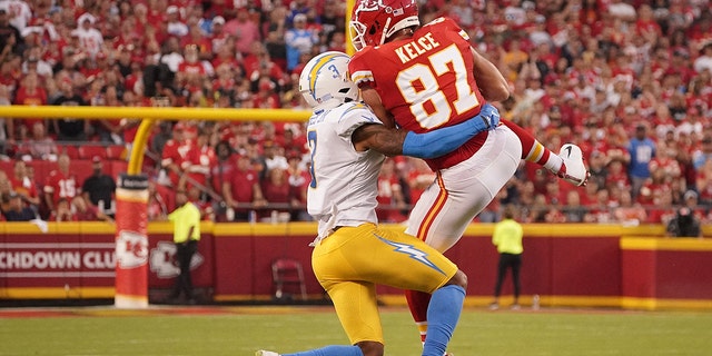 Sep 15, 2022; Kansas City, Missouri, USA; Kansas City Chiefs tight end Travis Kelce (87) catches a pass against Los Angeles Chargers safety Derwin James Jr. (3) during the first half at GEHA Field at Arrowhead Stadium.