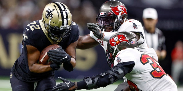 New Orleans Saints running back Mark Ingram II is tackled by Tampa Bay Buccaneers linebacker Devin White and safety Mike Edwards during the first half of an NFL football game in New Orleans, Sunday September 18, 2022.