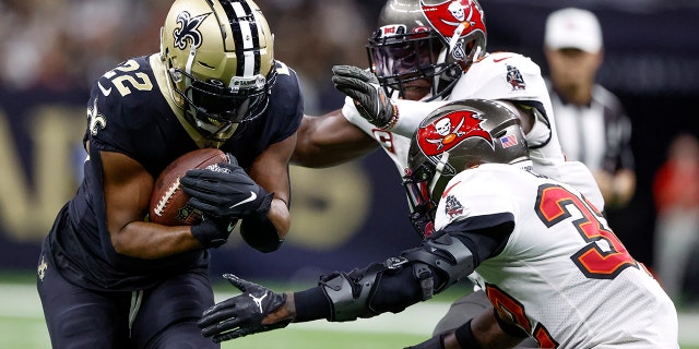 New Orleans Saints running back Mark Ingram II is tackled by Tampa Bay Buccaneers linebacker Devin White and safety Mike Edwards during the first half in New Orleans on Sept. 18, 2022.