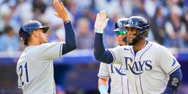 Yandy Diaz, right, of the Tampa Bay Rays celebrates this home run with Rene Pinto against the Toronto Blue Jays in the second inning during a game at the Rogers Centre Sept. 15, 2022, in Toronto, Ontario, Canada.