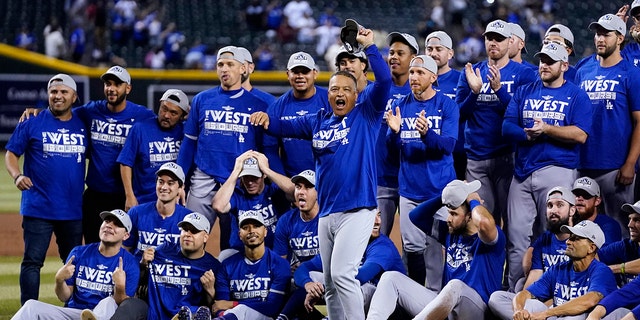 Los Angeles Dodgers manager Dave Roberts, front, cheers with the team in the background after the Dodgers' baseball game against the Arizona Diamondbacks in Phoenix, Tuesday, Sept. 13, 2022. 