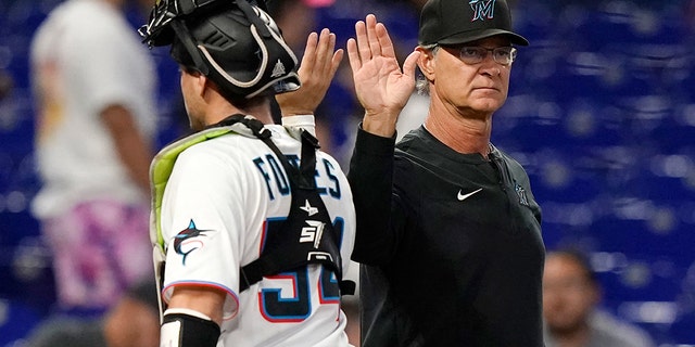 Miami Marlins manager Don Mattingly, right, high-fives catcher Nick Fortes after the second game of a doubleheader against the Texas Rangers, Sept. 12, 2022, in Miami.