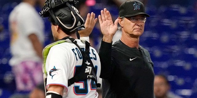 Miami Marlins manager Don Mattingly, right, high-fives catcher Nick Fortes after the second game of a doubleheader against the Texas Rangers on Sept. 12, 2022, in Miami.