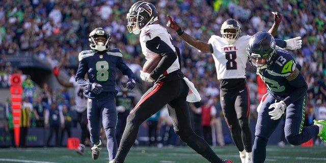 Atlanta Falcons wide receiver Drake London, center, scores a touchdown during the second half of an NFL football game against the Atlanta Falcons, Sunday, Sept. 25, 2022, in Seattle. 