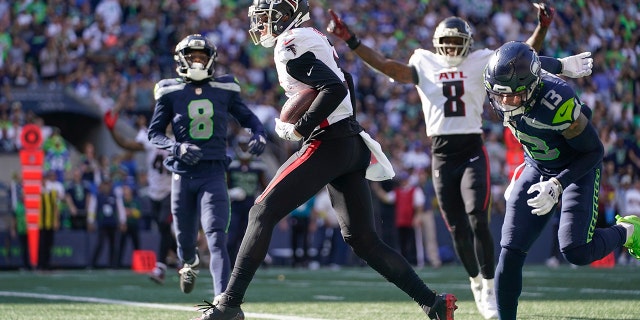 Atlanta Falcons wide receiver Drake London (center) scores a touchdown during the second half of an NFL football game against the Atlanta Falcons in Seattle on September 25, 2022. 