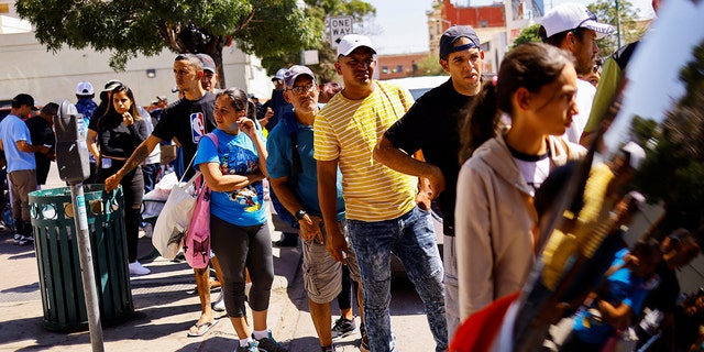 Migrants gather to receive donated clothing near a bus station after being released from US Border Patrol custody in El Paso, Texas.
