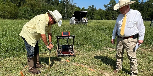 Mark Edwards, left, a search coordinator for Texas EquuSearch, used ground-penetrating radar to determine a disturbance in the soil, then traced its shape with a metal probe.