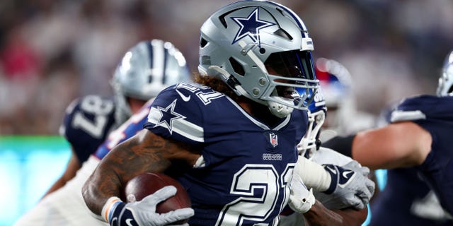 Ezekiel Elliott #21 of the Dallas Cowboys plays the ball against Nick Williams #93 of the New York Giants during the third quarter of the game at MetLife Stadium on September 26, 2022 in East Rutherford, New Jersey.