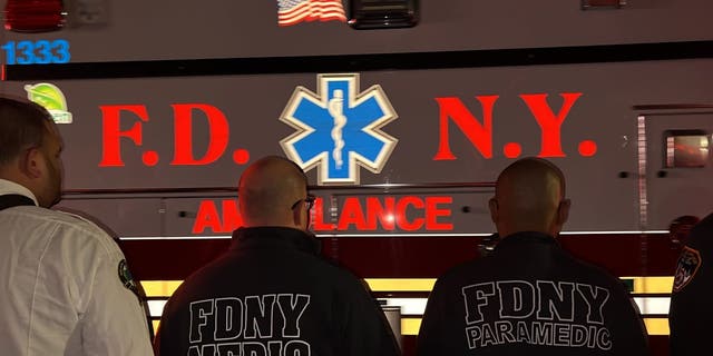 An ambulance carrying the body of slain FDNY paramedic Lt. Alison Russo-Elling passes through a crowd of FDNY EMS personnel. 