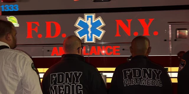 An ambulance carrying the body of slain FDNY paramedic Lt. Alison Russo-Elling passes through a crowd of New York City Fire Department EMS personnel.