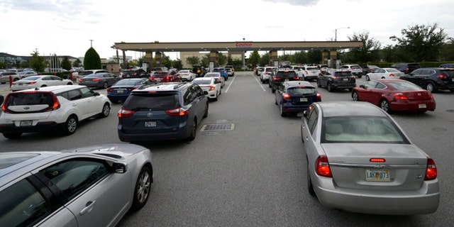 People wait in lines to fuel their vehicles at a Costco Wholesale store in preparation for the arrival of Hurricane Ian, Monday, Sept. 26, 2022, in Orlando, Florida.