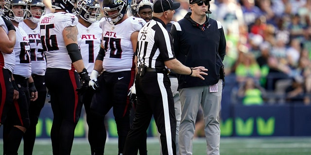 Atlanta Falcons head coach Arthur Smith, right, looks on as players are asked to vacate the field as part of a security timeout during the second half of a game against the Seattle Seahawks Sept. 25, 2022, in Seattle. 