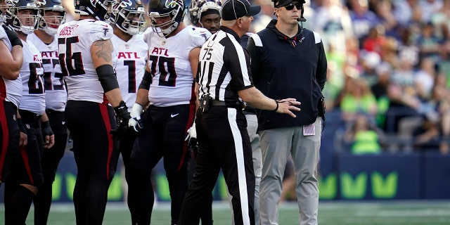 Atlanta Falcons head coach Arthur Smith, right, looks on as players are asked to vacate the field as part of a security timeout during the second half of a game against the Seattle Seahawks Sept. 25, 2022, in Seattle. 