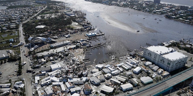 Damages boats lie on the land and water in the aftermath of Hurricane Ian, Thursday, Sept. 29, 2022, in Fort Myers, Florida.