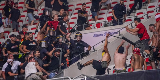 Nice supporters, bottom left, clash with FC Koln supporters, right, prior to the start of the Europa Conference League Group D match between OCG Nice and FC Koln at the Allianz Riviera stadium in Nice, France, Thursday, Sept. 8, 2022.