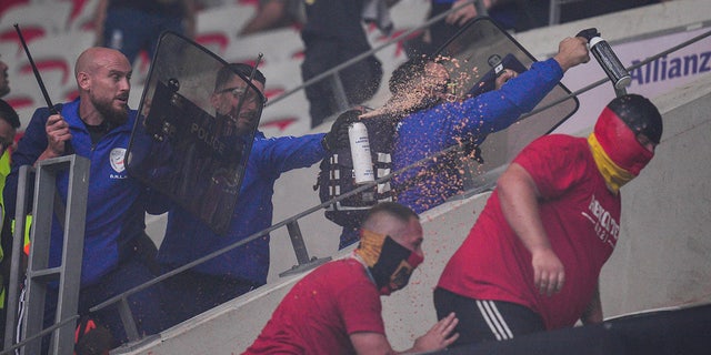 French policemen, left, use tear sprays to disperse FC Koln supporters during clashes prior to the start of the Europa Conference League Group D match between Nice and FC Koln at the Allianz Riviera stadium in Nice, France, Thursday, Sept. 8, 2022.