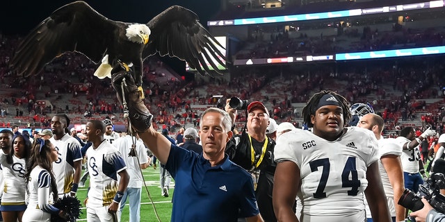 Offensive lineman Pichon Wimbley #74 of the Georgia Southern Eagles walks off the field with the mascot eagle after the victory against the Cornhuskers at Memorial Stadium on Sept. 10, 2022, in Lincoln, Nebraska.