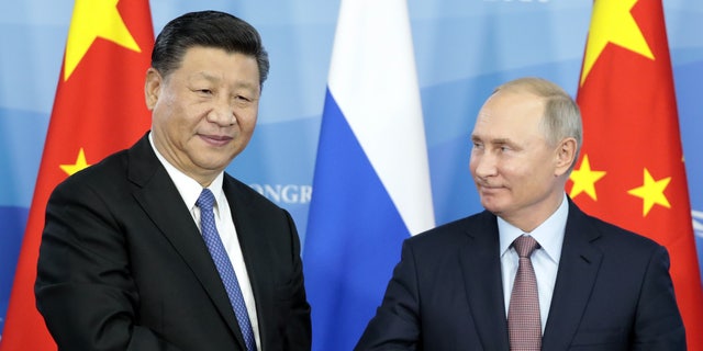 Russian President Vladimir Putin, right, shakes hands with Chinese President Xi Jinping during a signing ceremony following the Russian-Chinese talks on the sidelines of the Eastern Economic Forum in Vladivostok, Russia, on Sept. 11, 2018. (Sergei Chirikov / Pool / AFP via Getty Images)