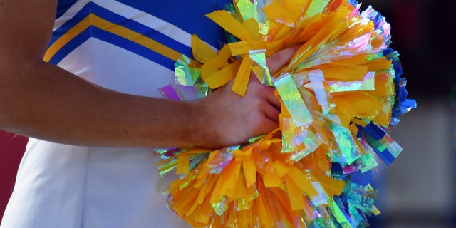 Cheerleader with rainbow pom poms