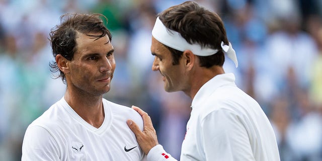 Roger Federer of Switzerland, right, shakes hands with Rafael Nadal of Spain after defeating him in a men's singles semifinal at Wimbledon July 12, 2019, in London.  