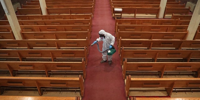 David Rossini, da Bostonian Cleaning and Restoration of Braintree, limpa o corredor da Igreja de St. Gregory em Dorchester, em Boston, durante a pandemia de COVID-19 em 18 de maio de 2020.
