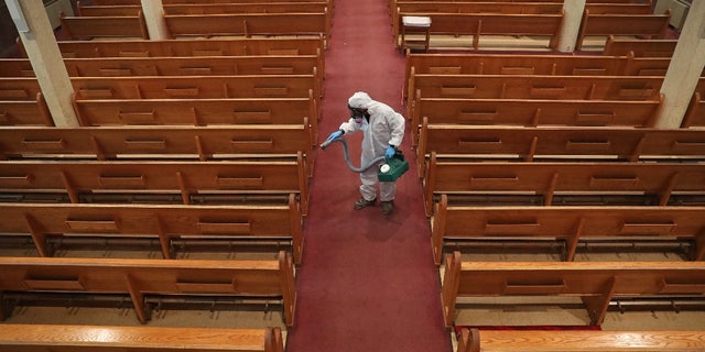 David Rossini of Bostonian Cleaning and Restoration of Braintree cleans the aisles of St. Gregory's Church in Dorchester, Boston during the COVID-19 pandemic on May 18, 2020.