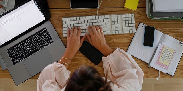 Une femme travaille sur un ordinateur de bureau dans un bureau à domicile à Berne, en Suisse, le samedi 22 août 2020.
