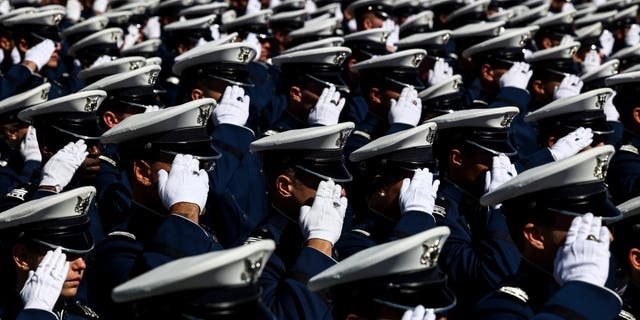 Air Force Academy cadets salute during the national anthem at Falcon Stadium for their graduation ceremony on May 25, 2022, in Colorado Springs, Colorado.