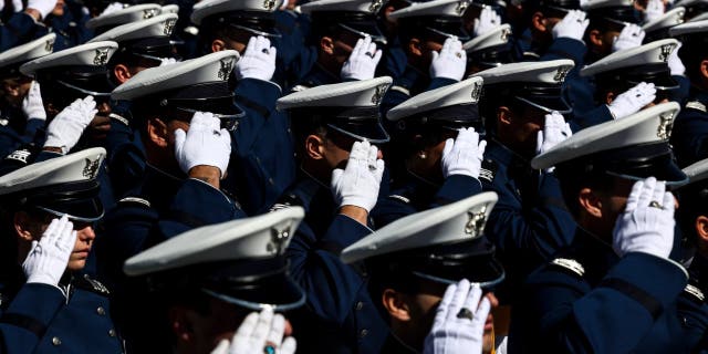 Air Force Academy cadets salute during the national anthem at Falcon Stadium for their graduation ceremony on May 25, 2022, in Colorado Springs, Colorado.