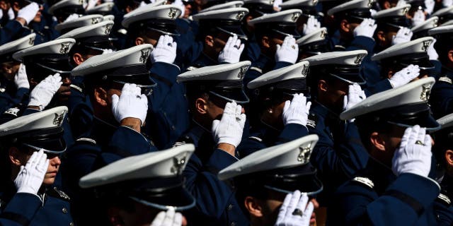 Air Force Academy cadets salute during the national anthem at Falcon Stadium for their graduation ceremony May 25, 2022, in Colorado Springs, Colo. 