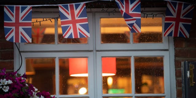 Union Jack flags hang from the window of a pub. The number of pubs in England and Wales has fallen to an all-time low, according to a recent evaluation.