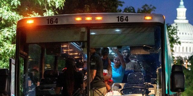 Migrants from Venezuela, who boarded a bus in Del Rio, Texas, disembark within view of the US Capitol in Washington, DC, on August 2, 2022. - Since April, Texas Governor Greg Abbott has ordered over 150 buses to carry approximately 4,500 migrants from Texas to Washington, DC, to highlight criticisms of US President Joe Bidens border policy.