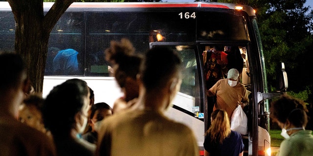 Migrants from Venezuela, who boarded a bus in Del Rio, Texas, disembark within view of the US Capitol in Washington, DC, on August 2, 2022.