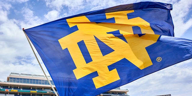A cheerleader celebrates by waving a Notre Dame Fighting Irish flag during the Notre Dame Blue-Gold Spring Football Game at Notre Dame Stadium in South Bend, Indiana, on April 23, 2022.