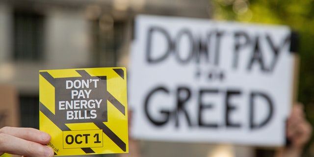 A protester holds a placard that says "Don't pay energy bills" during a "Don't Pay UK" demonstration. The "Don't Pay UK" protest encourages supporters to cancel their direct debit payments to energy companies en masse on October 1.