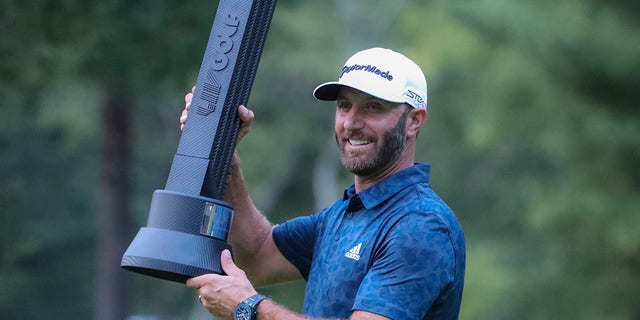 Dustin Johnson holding the winner's trophy after winning the LIV Golf Invitational Series Boston at The International Golf Course. 