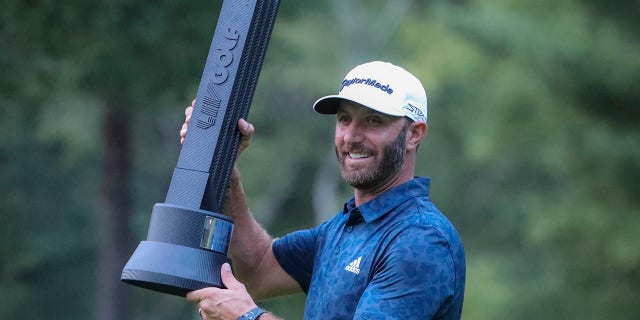 Dustin Johnson holding the winners trophy after winning the LIV Golf Invitational Series Boston at The International Golf Course.